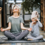 A smiling person doing yoga or holding healthy food with nature in the background.